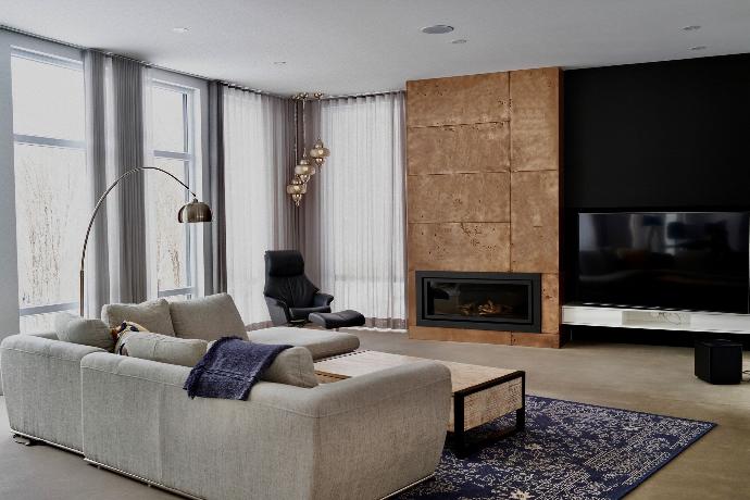 Modern living room with a gas fireplace covered in copper metal panels